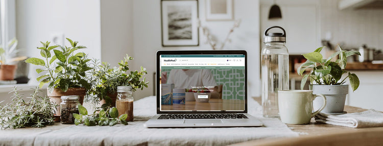 Computer on a beige table surrounded by plants