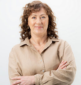 Woman wearing a beige shirt with arms crossed on a white background
