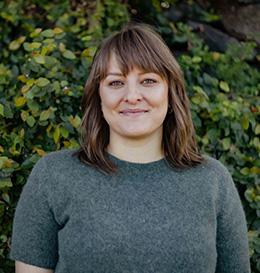 Woman standing in front of a green leafy background