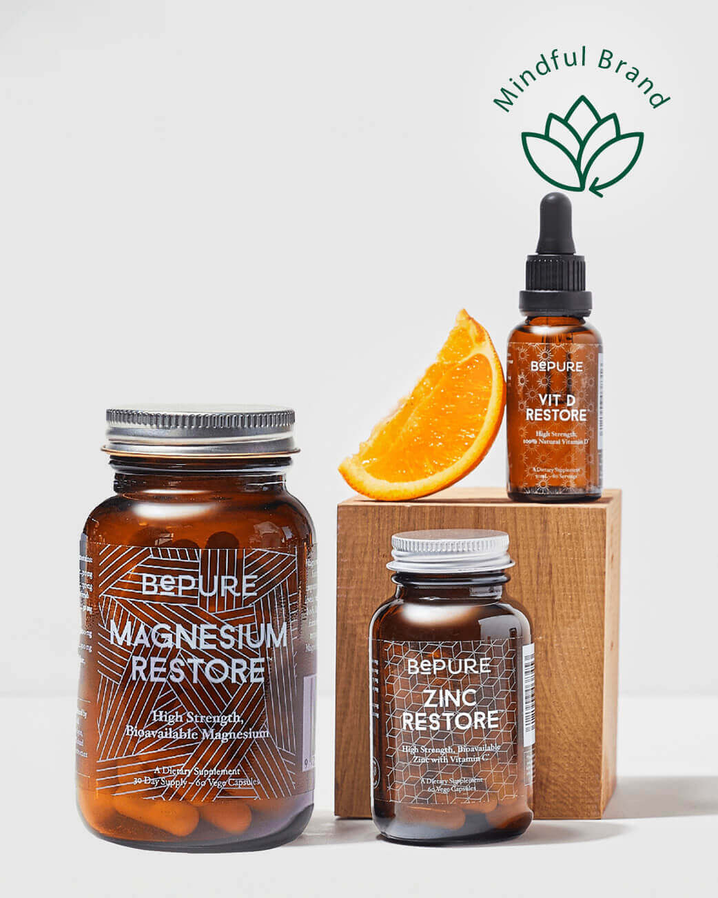 Three bottles of 'BePure' supplements on a white background with an orange slice and 'Mindful Brand' logo.
