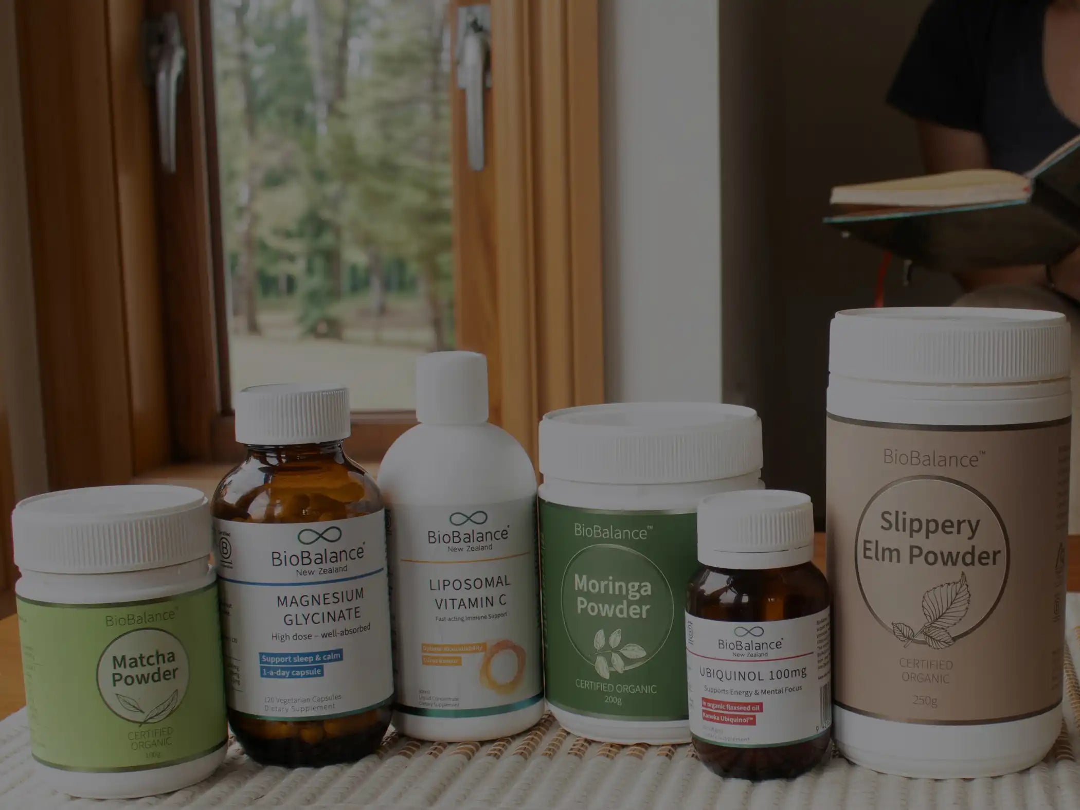 Collection of BioBalance health products on a wooden surface with a blurred background.