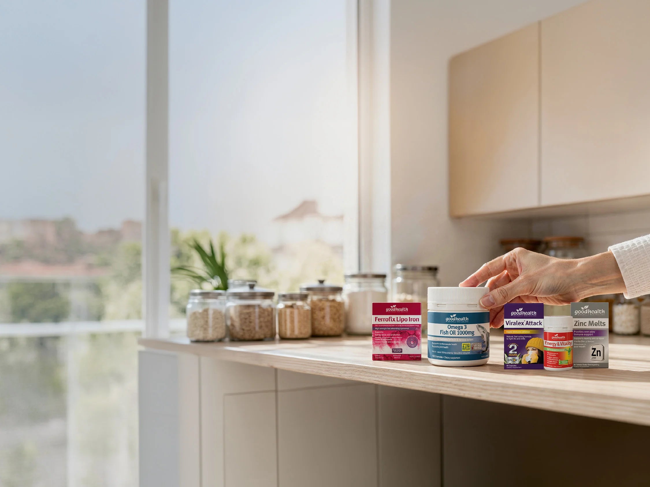 Person selecting a container from a kitchen counter with various jars and containers.