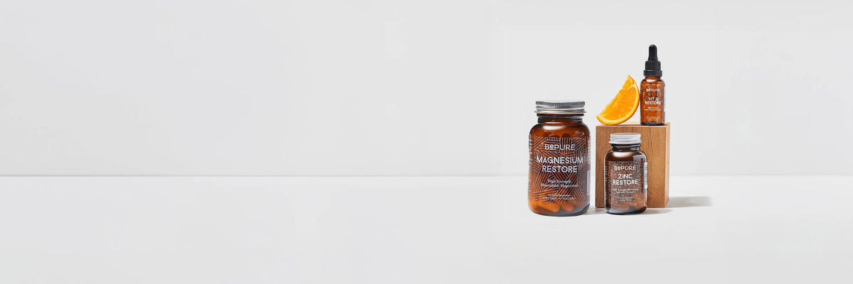 3 BePure products on a white background, with a slice of orange.