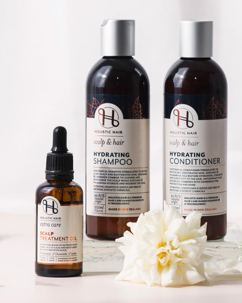 Holistic Hair care products including shampoo, conditioner, and treatment oil on a white background.