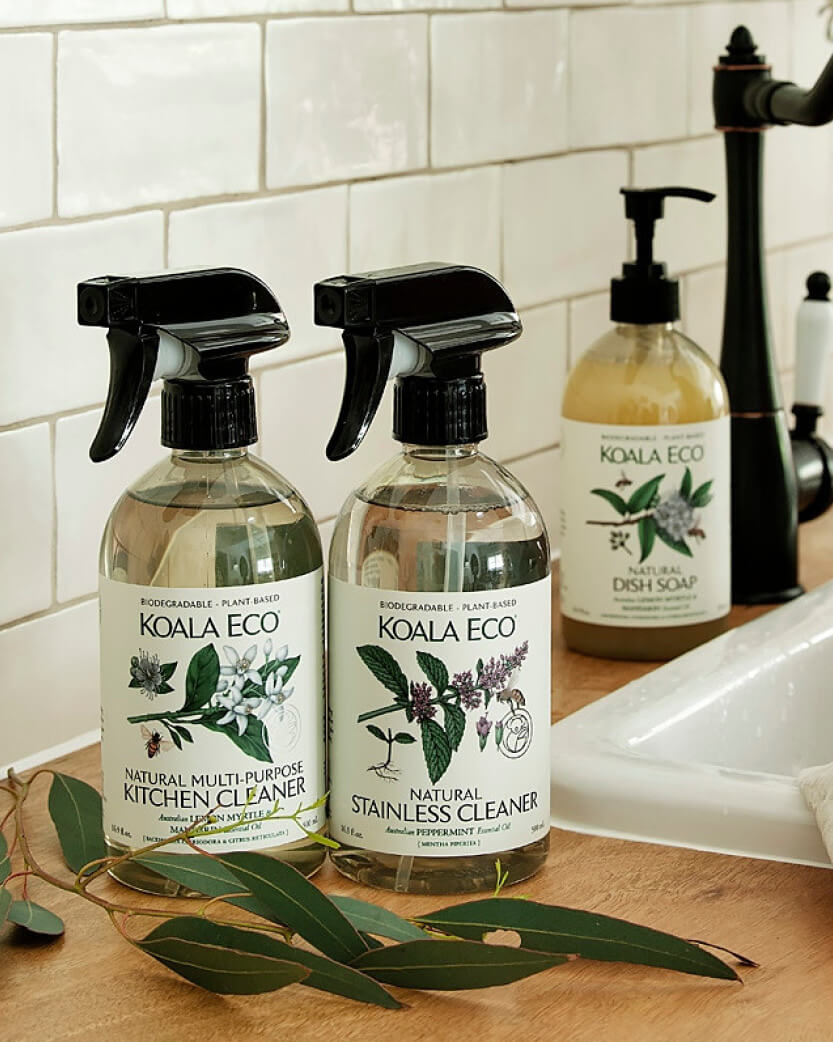 Two bottles of Koala Eco cleaning products on a kitchen counter with a tiled wall background.