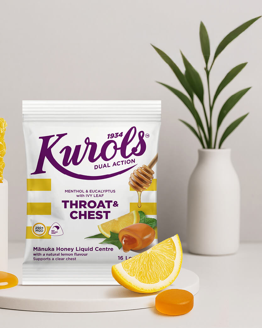 Kurols throat and chest lozenge package with lemon wedge and honey on a white surface.