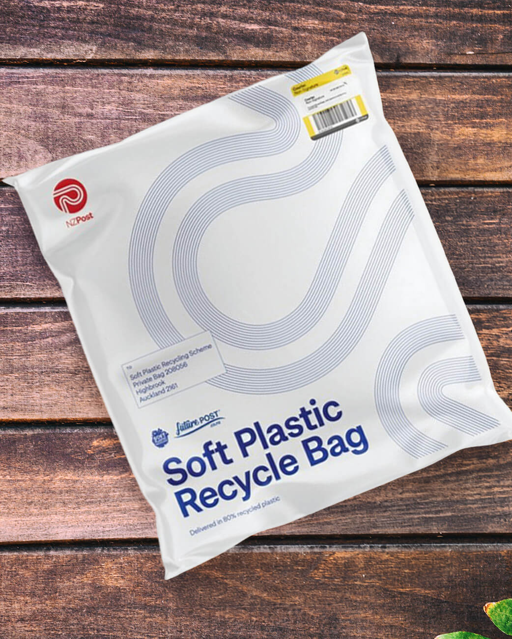 White soft plastic recycle bag with blue text on a wooden surface.