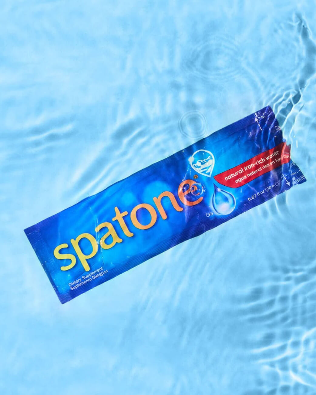 Spatone box floating on water with a blue background.