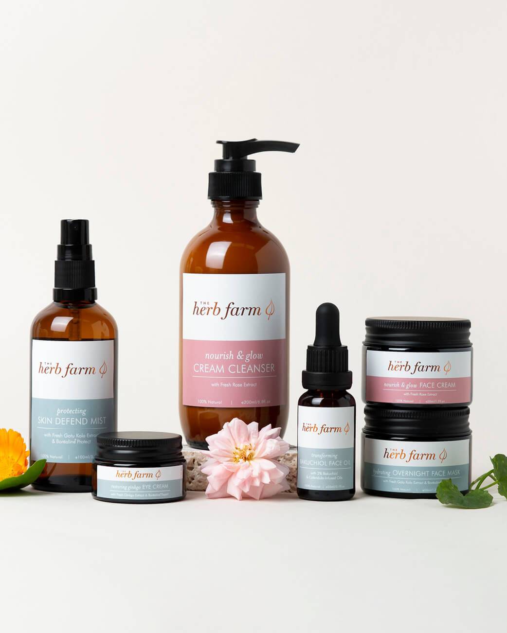 Collection of Herb Farm skincare products on a white background with flowers.