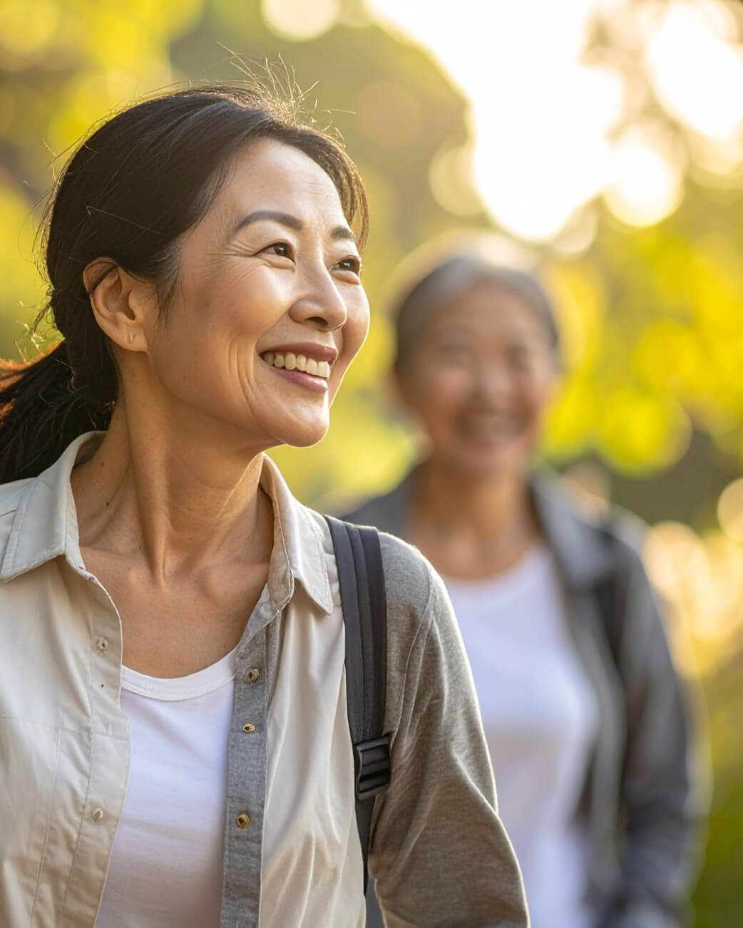 Two women walking outdoors with a blurred background.