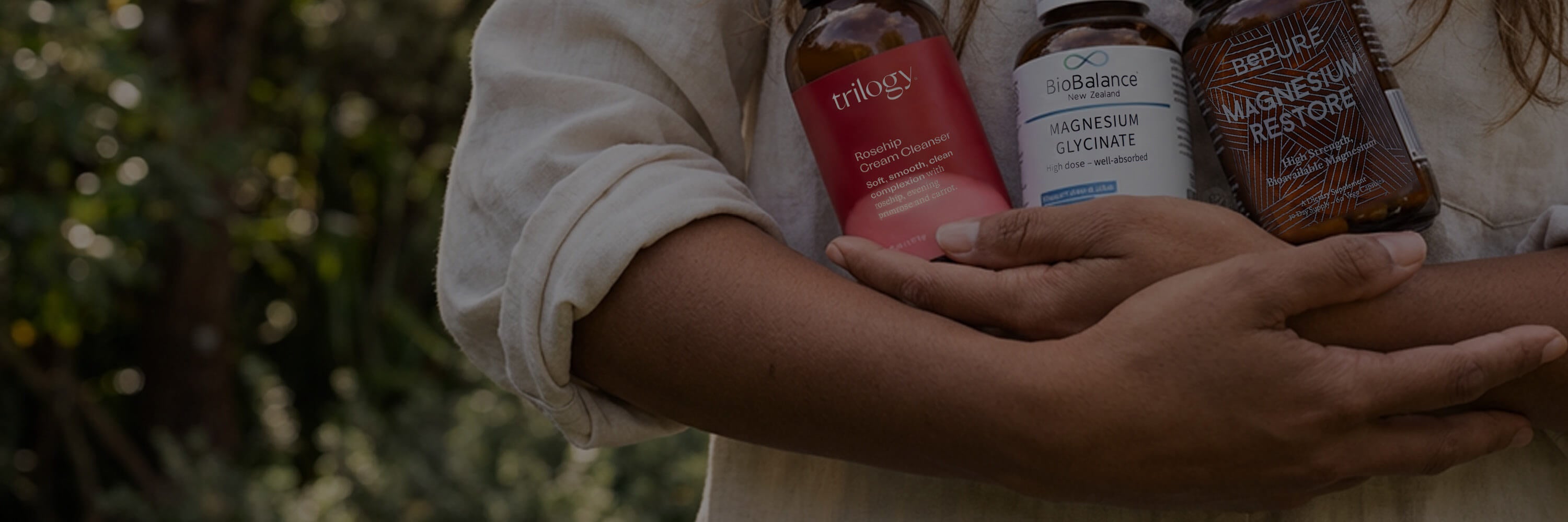 Person holding wellness and supplement bottles.