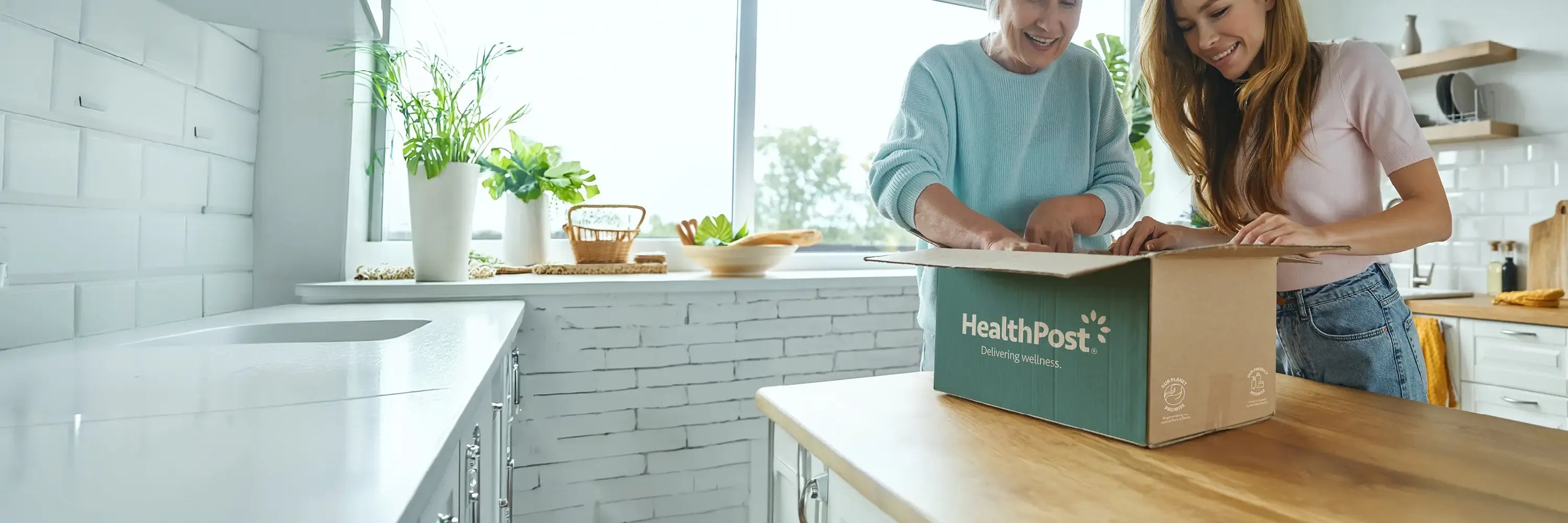 Two people opening a box labeled 'HealthPost' in a kitchen.