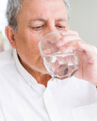 Man drinking from a glass of water.