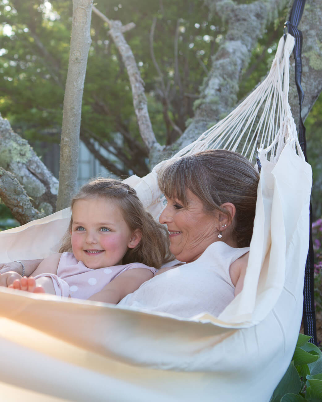 Woman and child in a hammock surrounded by nature.