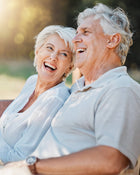 Senior couple laughing together outdoors.