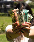 Person holding Chief Collagen Bars in an outdoor setting.