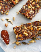 Nut and seed bars with a date on a marble surface