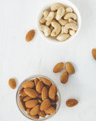 Bowl of almonds and cashews on a white surface