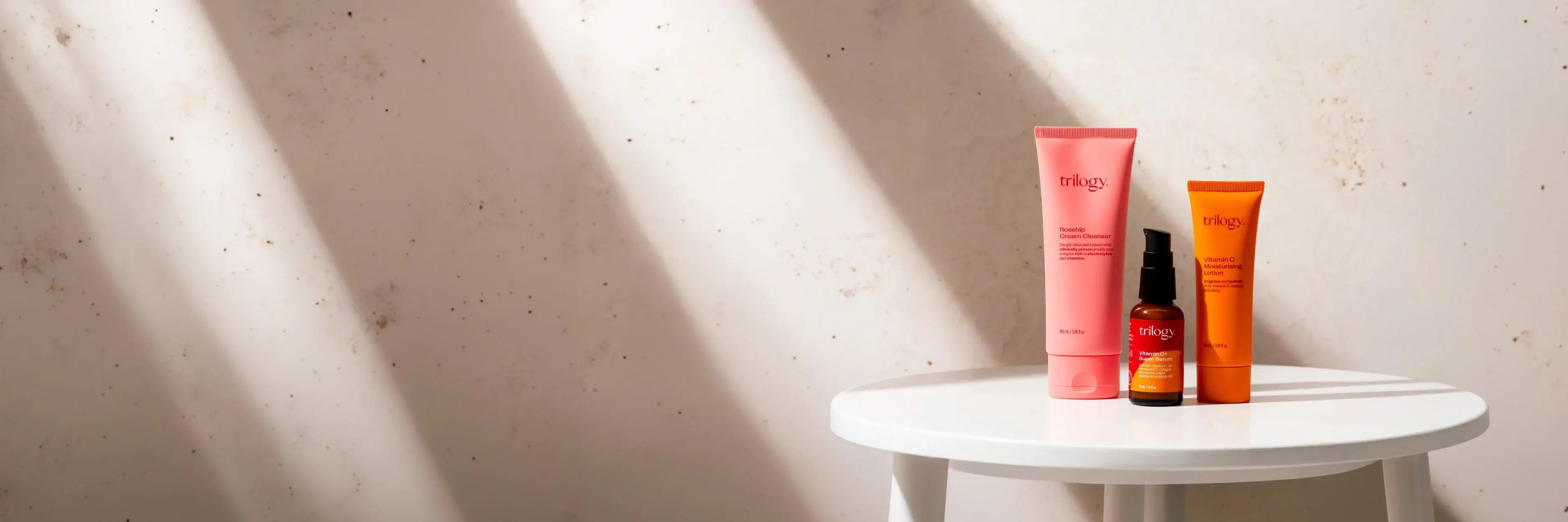 3 Trilogy products on a white table against a marble background.