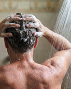 Man washing hair in the shower.