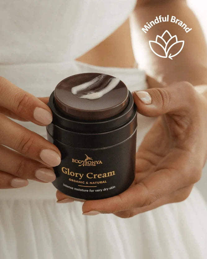 A person in a white dress holds an open jar of Eco By Sonya Glory Cream, showing the lightweight cream on the lid. A 'Mindful Brand' logo is visible in the top right corner.