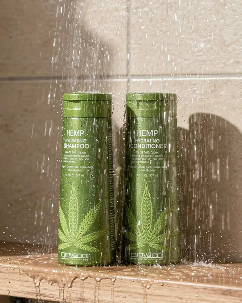 Two bottles of Hemp Shampoo and Conditioner under running water.