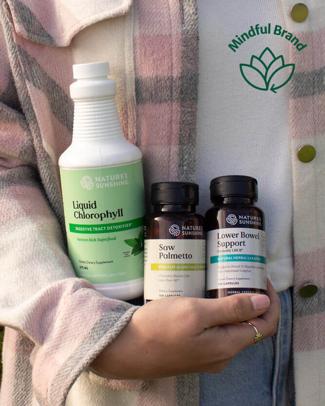 Person wearing pink jacket holding Nature's Sunshine products.