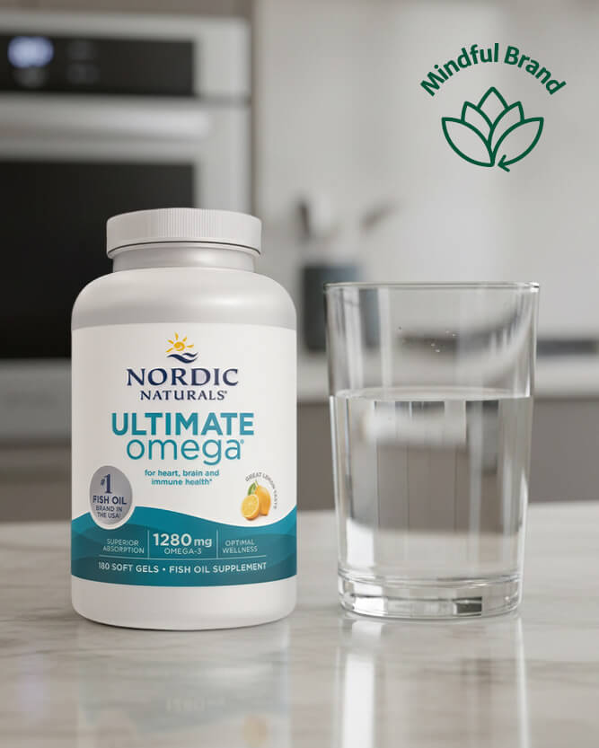 Nordic Naturals Ultimate Omega supplement bottle with a glass of water on a kitchen counter, featuring the Mindful Brand logo.