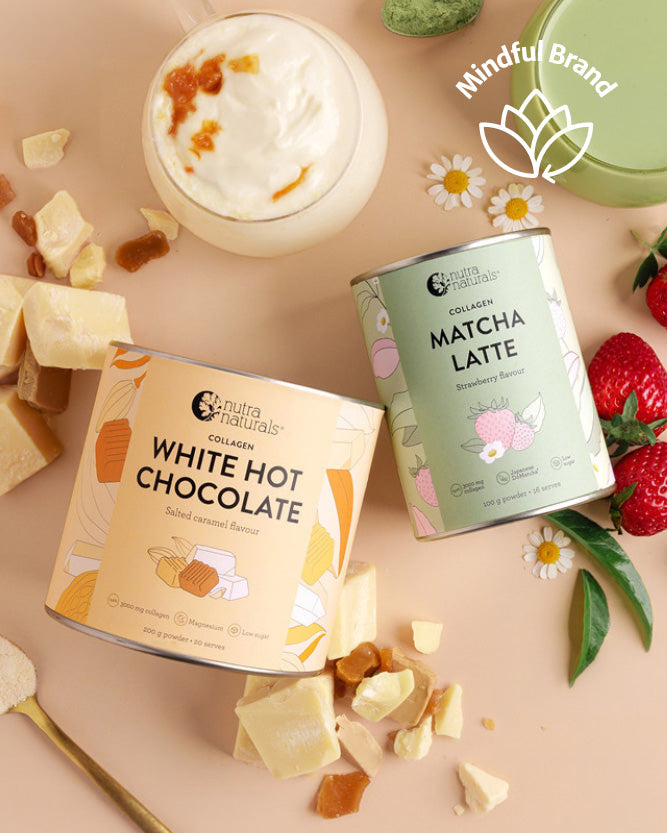 Two tins of Nutra Naturals hot chocolate and matcha latte on a beige background with white chocolate pieces and strawberries.