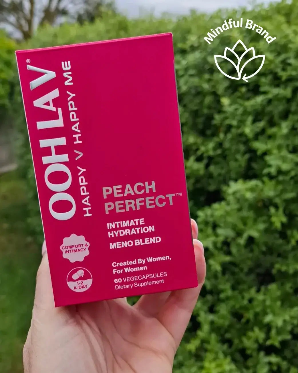 Pink Ooh La V supplement box held in a hand with greenery in the background.