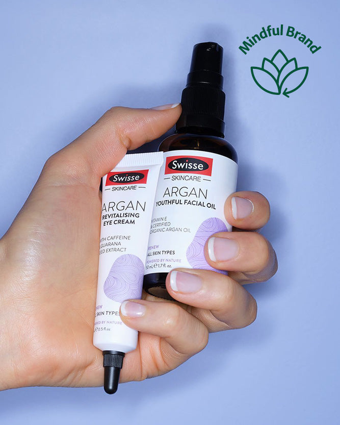 Hand holding Swisse skincare products with a blue background and 'Mindful Brand' logo.