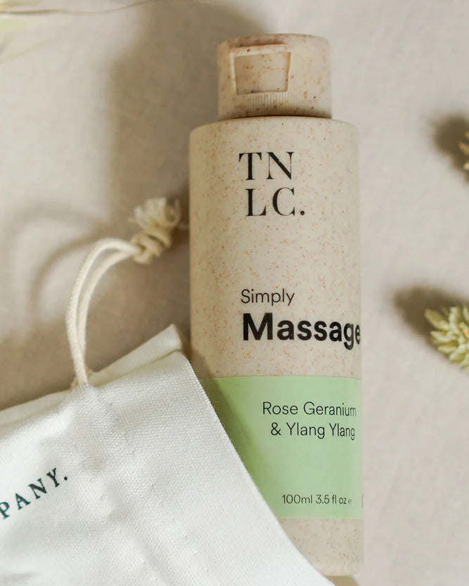 Massage oil bottle with 'TNLC' branding on a soft background