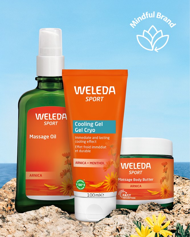 Weleda Arnica range pictured in a beach setting with a white mindful brand logo in the corner.