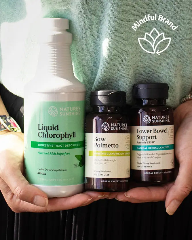 Three Nature's Sunshine herbal supplement products held in hands against a mint green shirt background: Liquid Chlorophyllly in a large white bottle, Sow Polmetto in a dark brown bottle, and Lower Bowel Support in a dark brown bottle. A 'Mindful Brand' logo is visible in the top right.