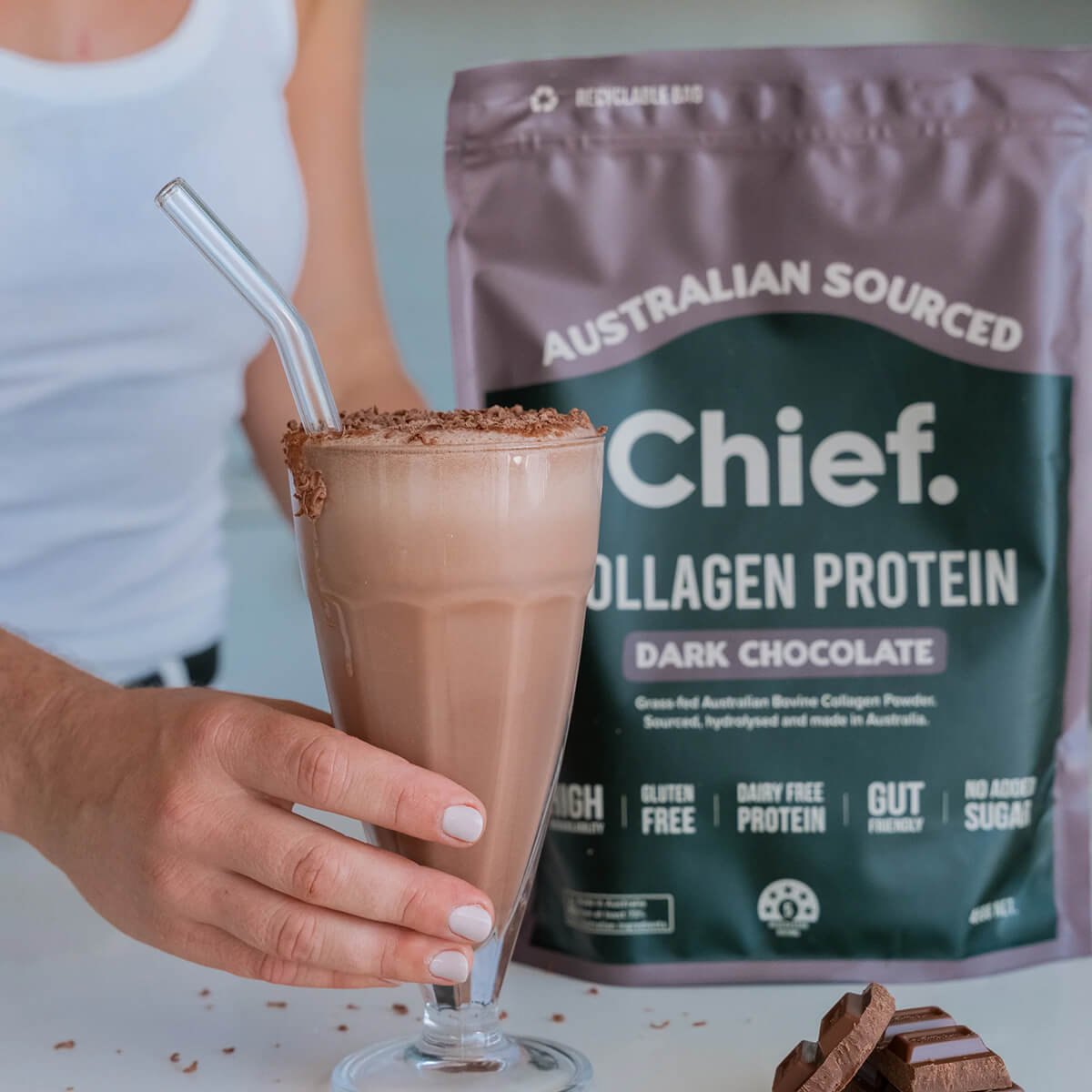 Glass of dark chocolate protein shake with a bag of Australian-sourced collagen protein in the background.