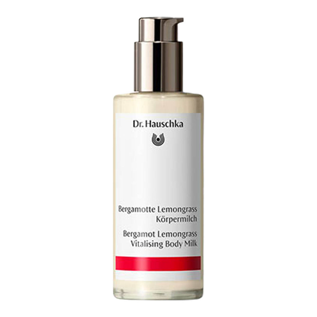 A bottle of Dr. Hauschka Bergamot Lemongrass Vitalising Body Milk, featuring a white label with black text and a red accent stripe, topped with a metallic silver pump dispenser, set against a plain white background.