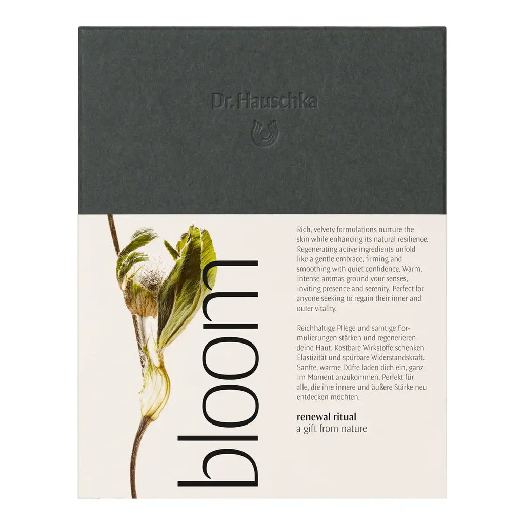 Dr. Hauschka gift set packaging, featuring a dark gray textured top section with embossed branding and a cream-colored bottom section with botanical illustrations.