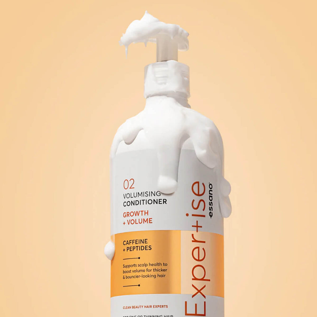 Bottle of Essence Expertise Volumising Conditioner on a beige background.