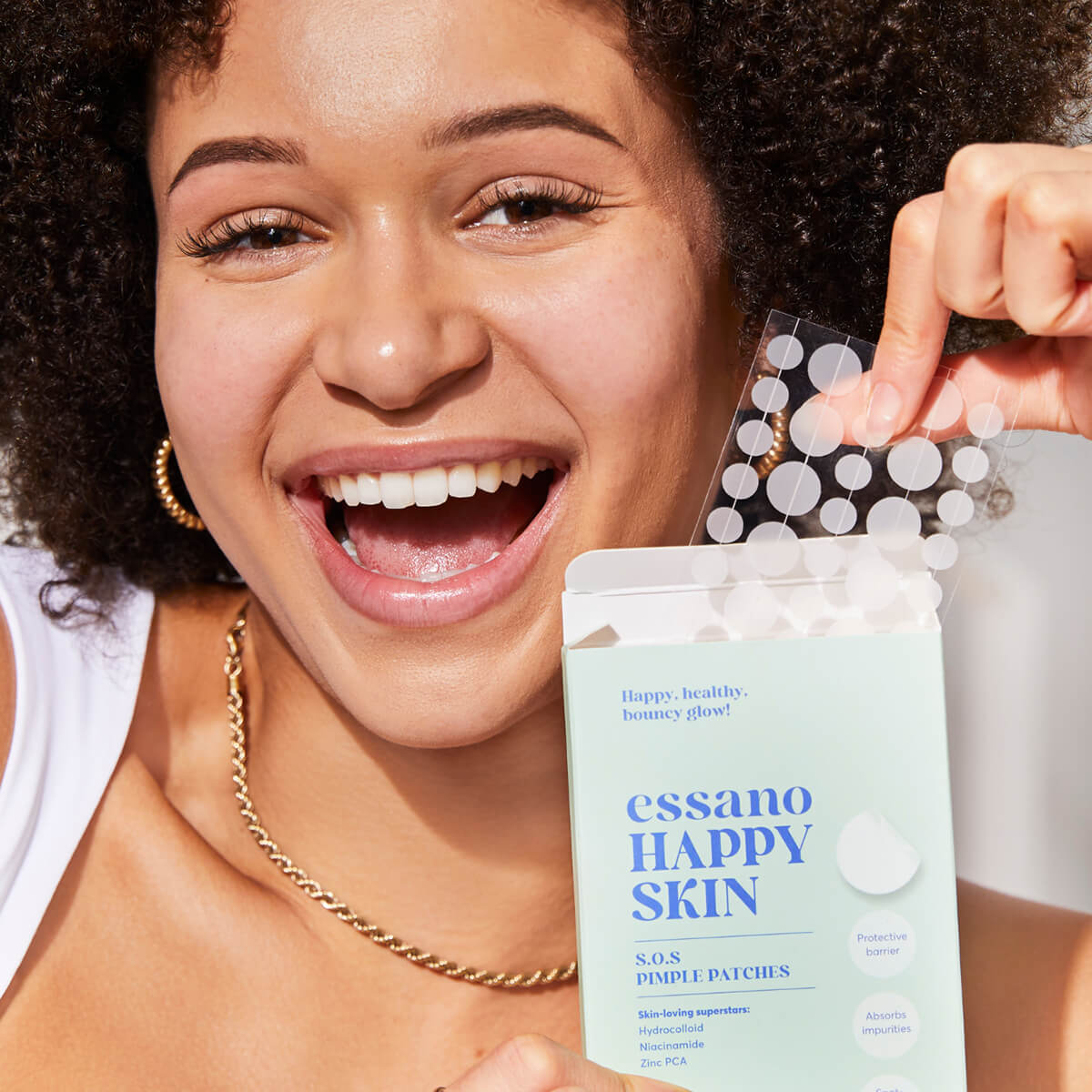 Woman holding essano Happy Skin product with a white background.