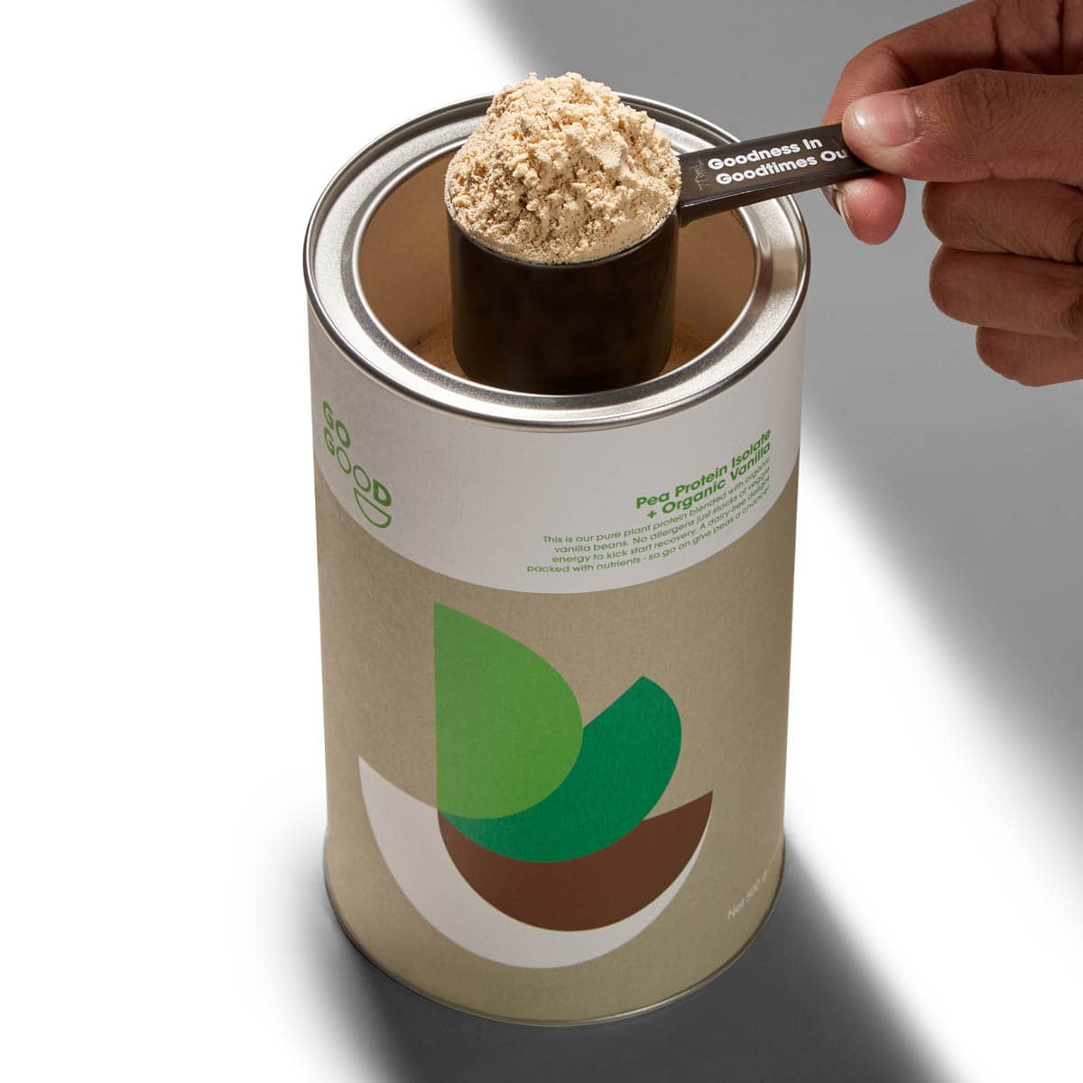 Canister of protein powder with a scoop being taken out, on a white background.