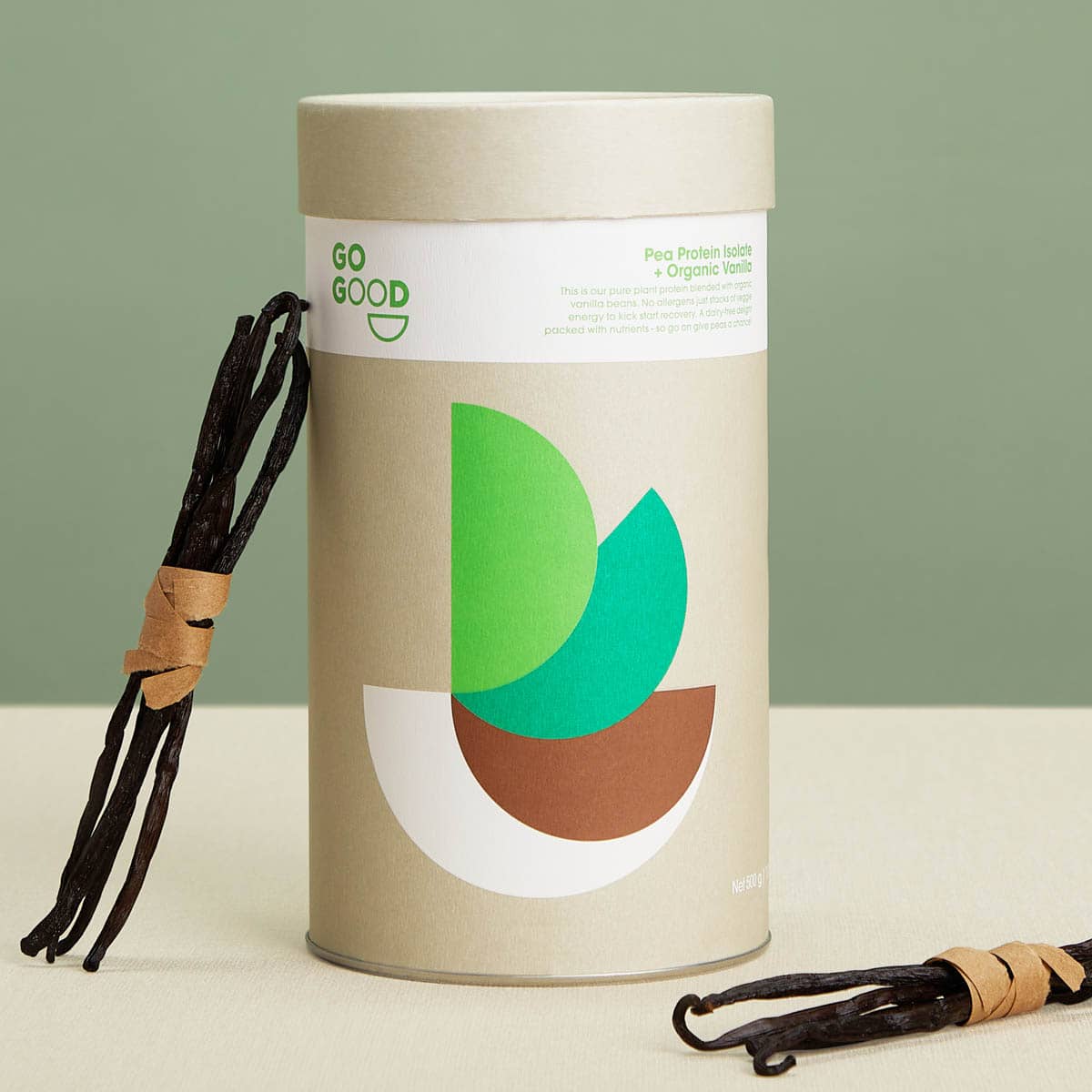 Vanilla beans next to a cylindrical container with green and brown design on a light background.