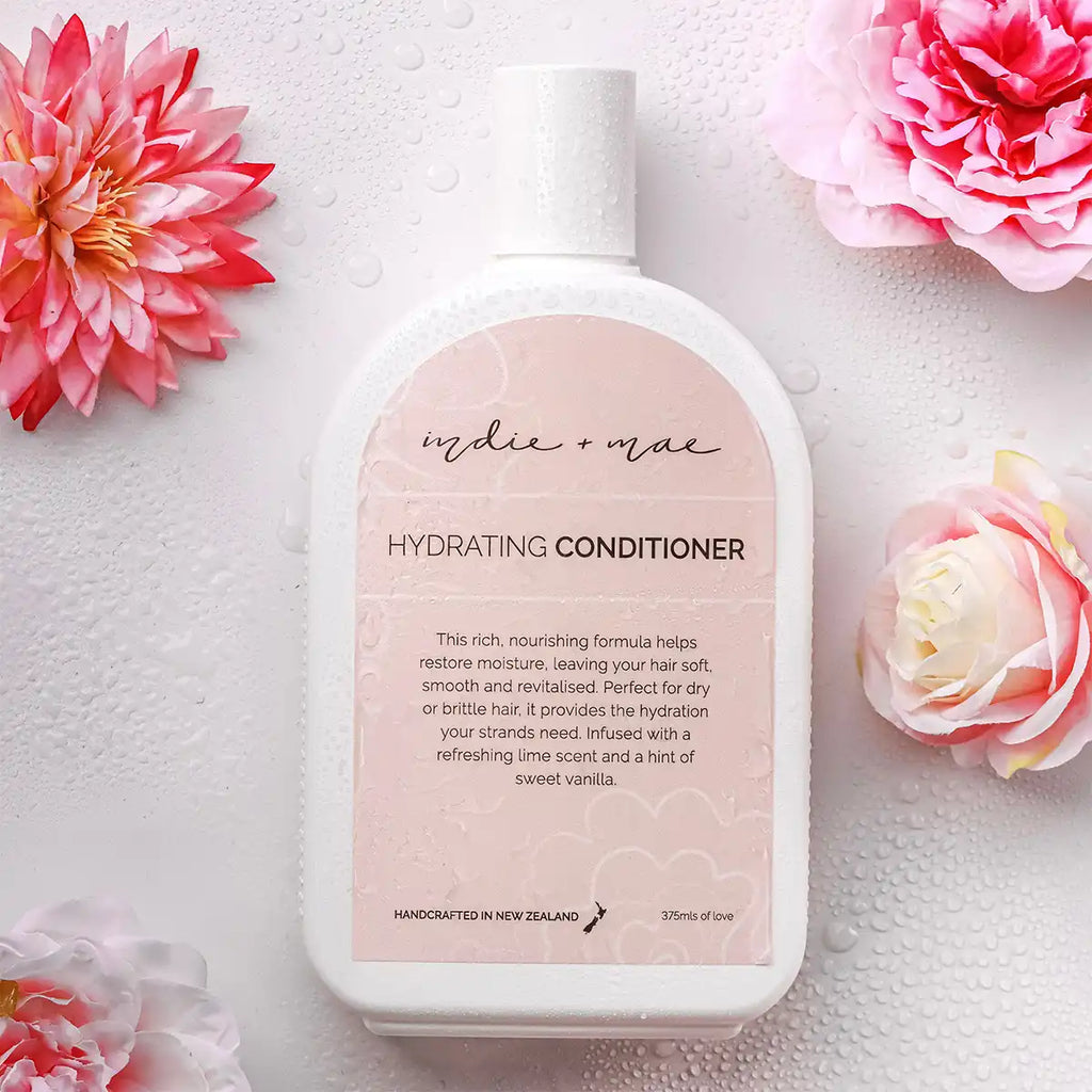 Hydrating conditioner bottle with pink flowers on a light background.