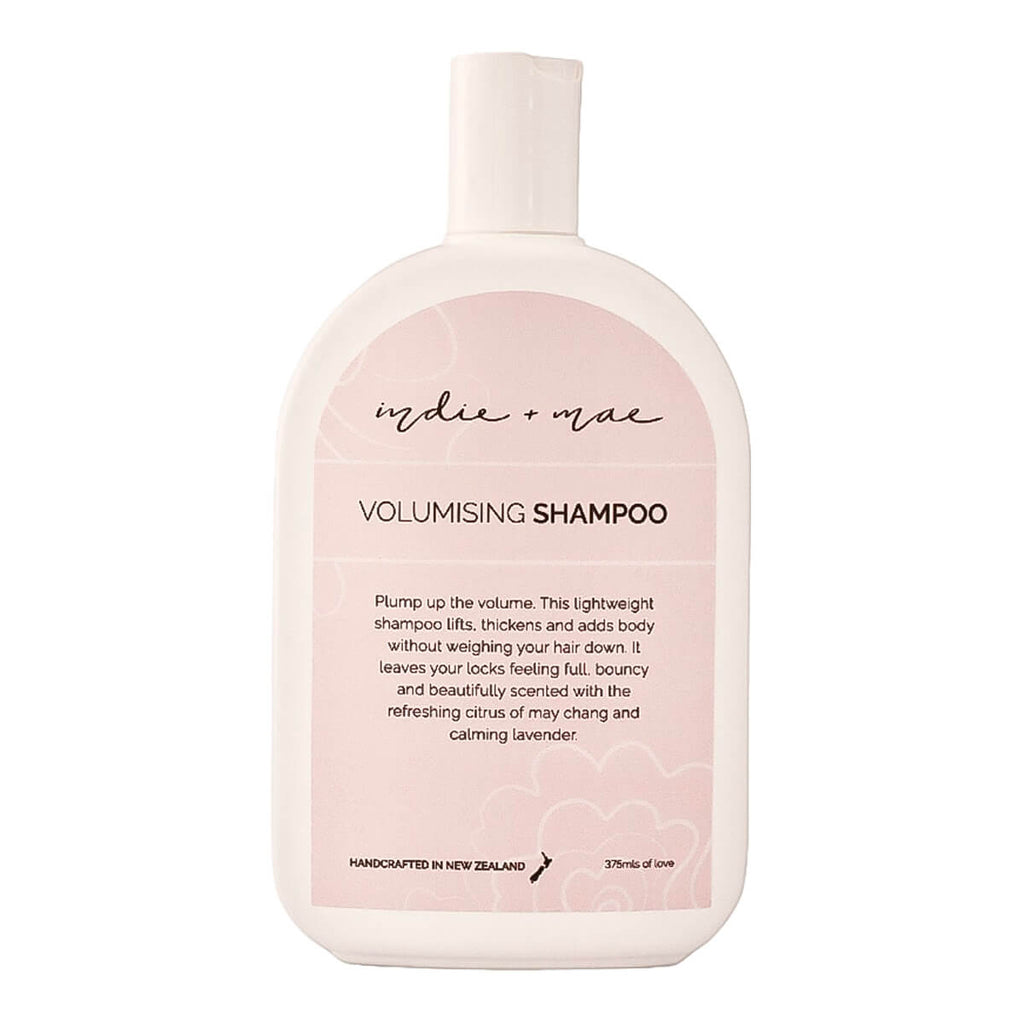 A 300ml bottle of Indie + Mae Volumising Shampoo, featuring a soft pink and white design with black text.