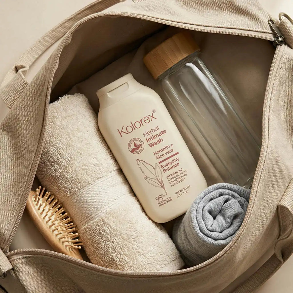 Open beige bag containing a bottle of Kolorex intimate wash, a towel, a brush, and a folded cloth.