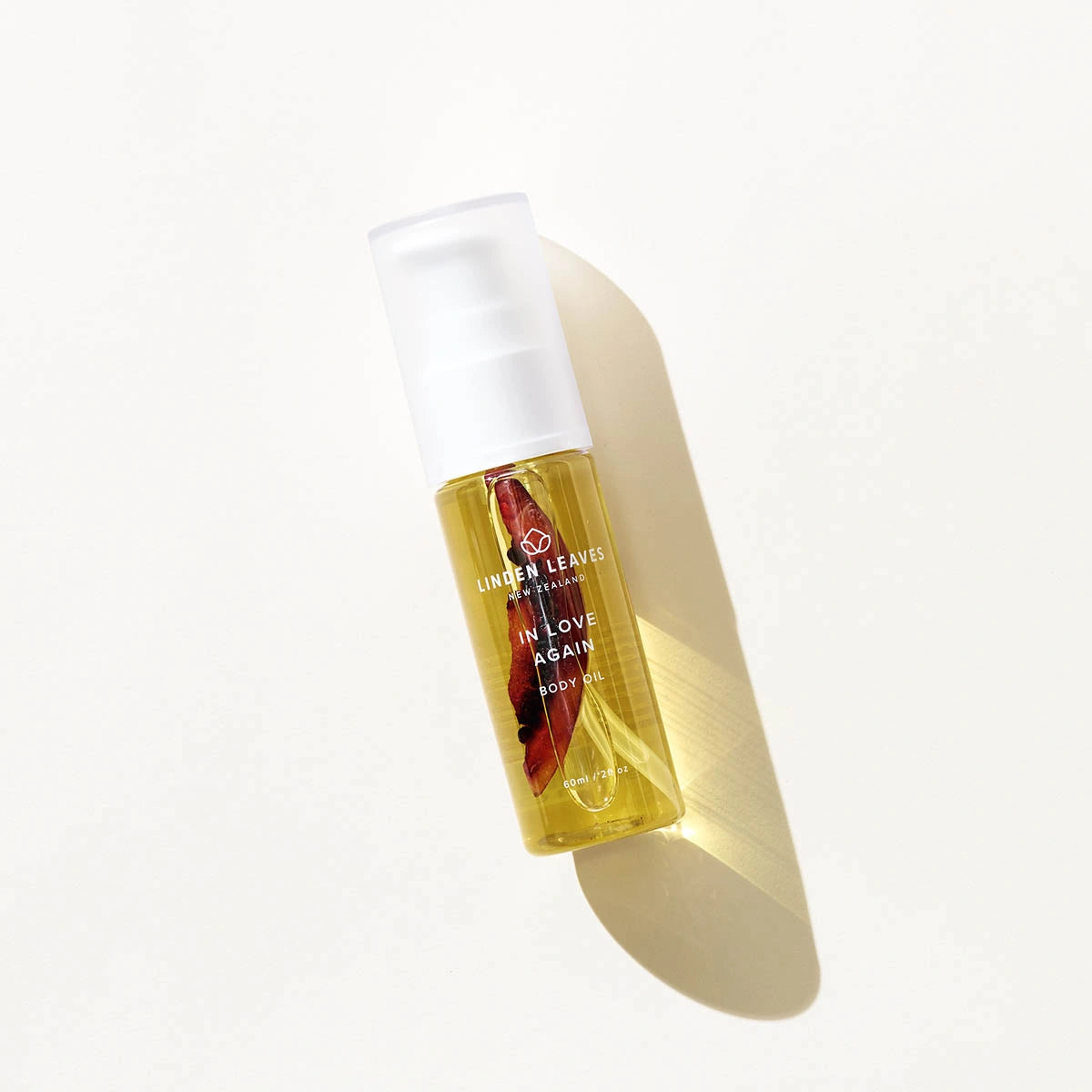 Bottle of Linen Leaves body oil on a white background
