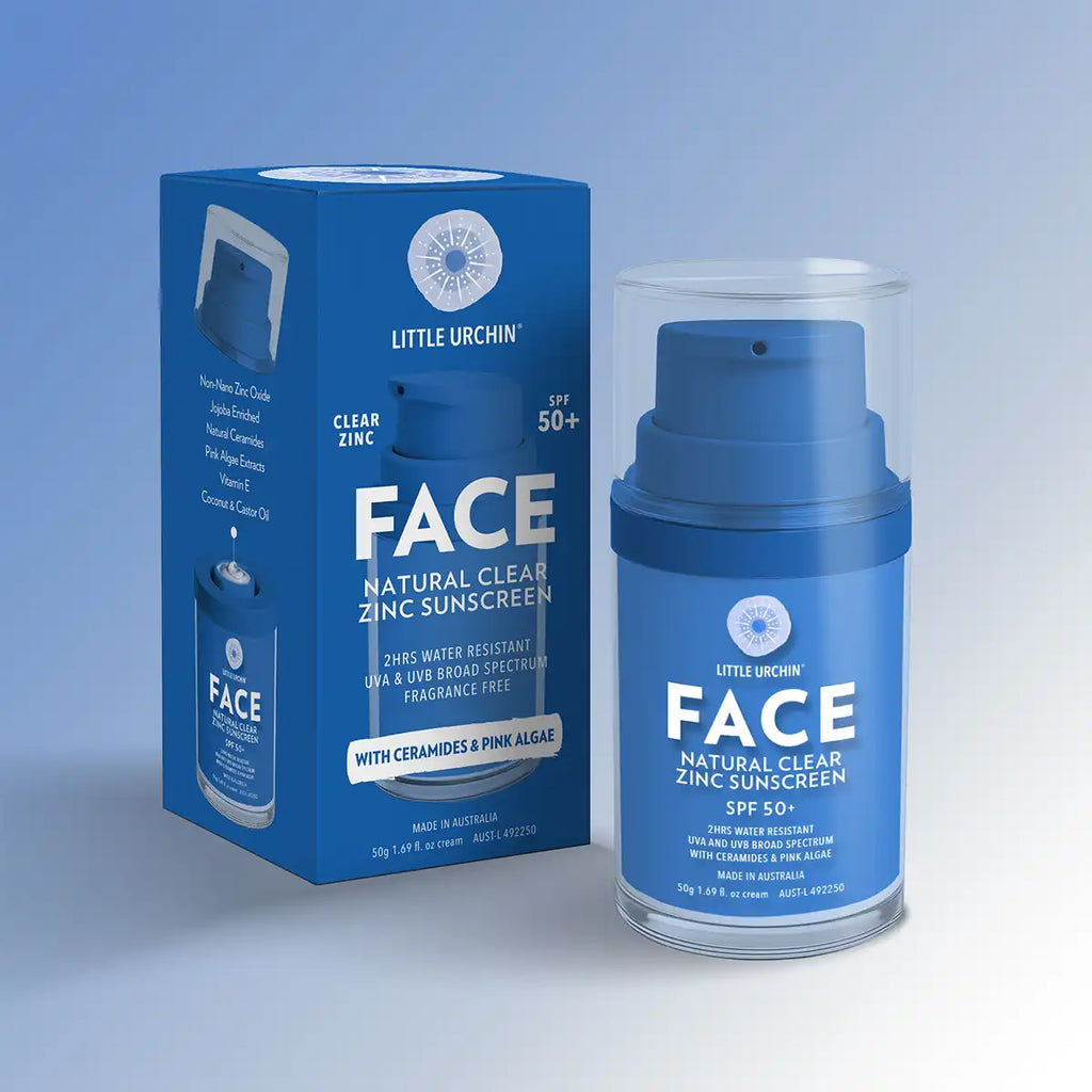 Little Urchin Face Natural Clear Zinc Sunscreen SPF 50+ shown with its blue retail box and the blue sunscreen bottle inside a clear cylindrical case, on a light blue studio background.