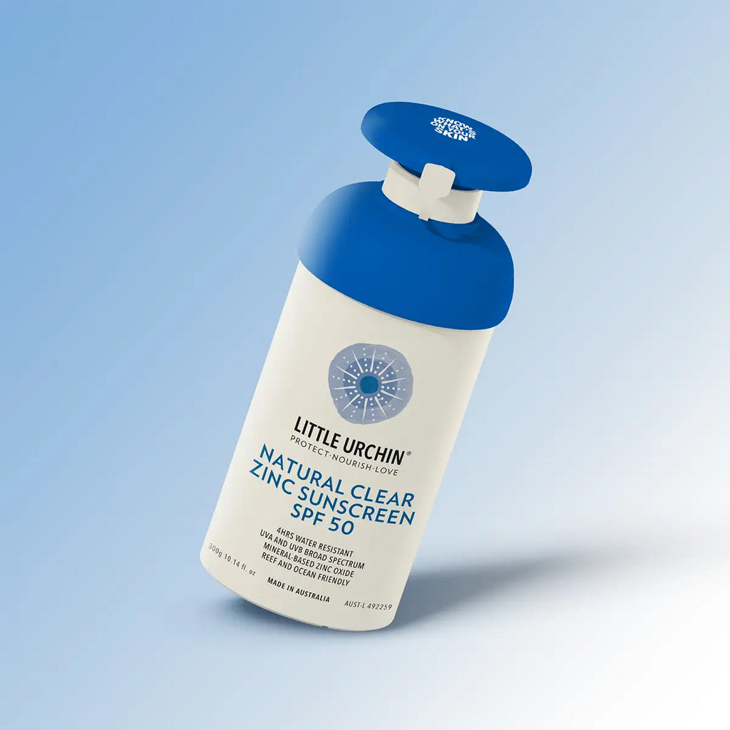 Little Urchin Natural Clear Zinc Sunscreen SPF 50 pump bottle tilted at an angle on a soft blue and white gradient background