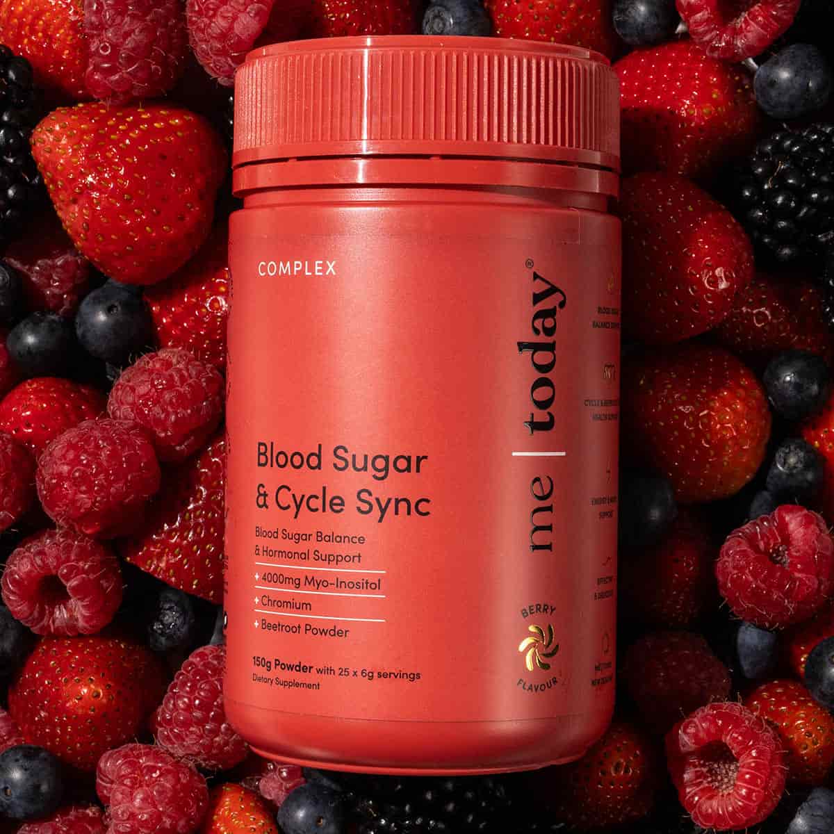 Blood sugar & cycle sync - red supplement bottle laying in a pile of mixed berries.