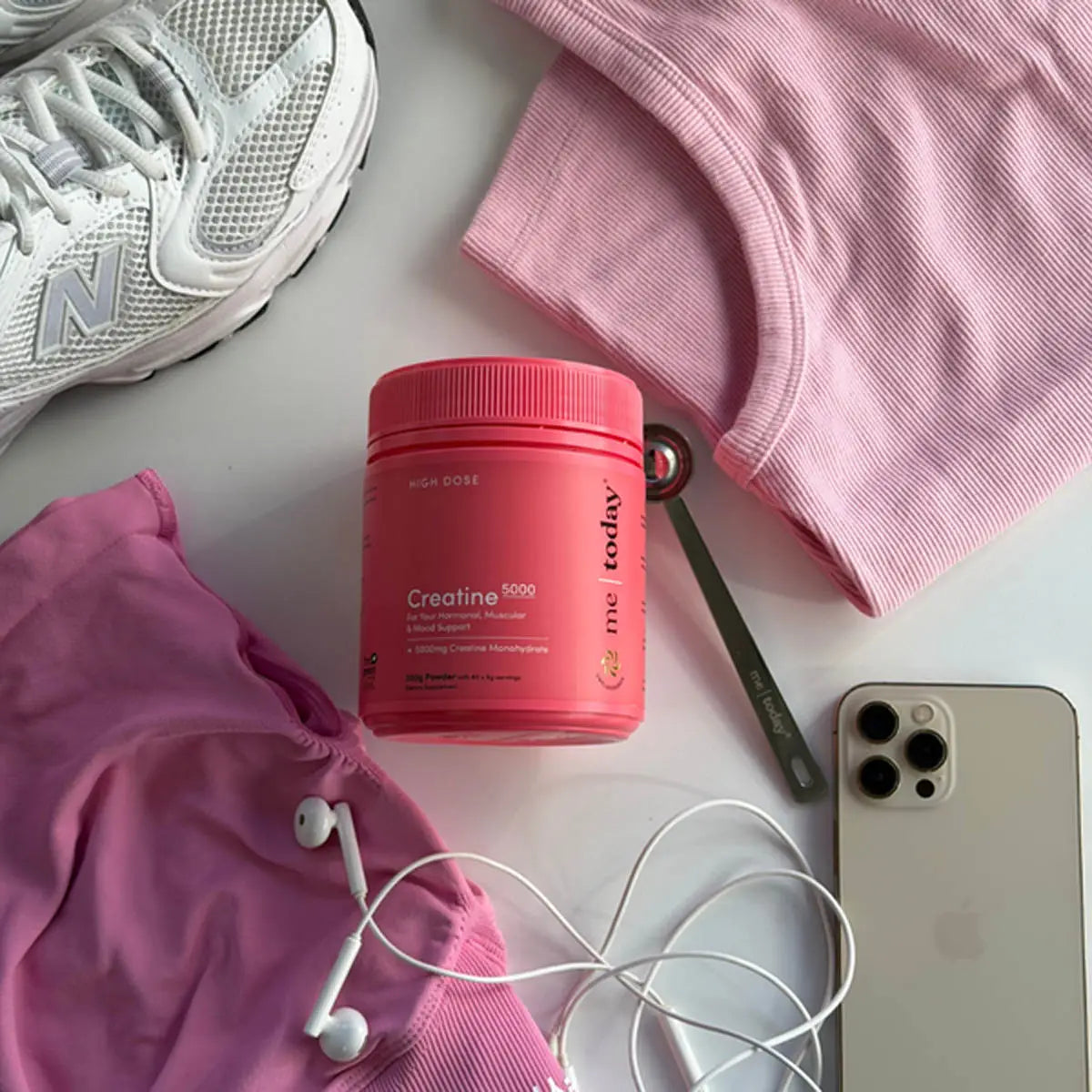 Me Today Creatine container amongst pink fitness gear. 