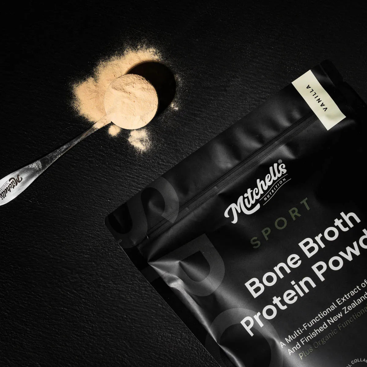 Mitchell's Sport Bone Broth Protein Powder packaging with a scoop of powder on a dark surface.